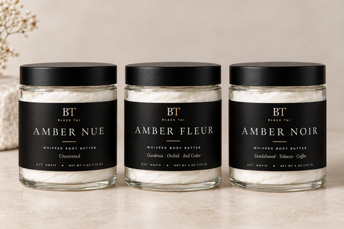Black Tai whipped body butters, including Amber Fleur, in clear glass jars with black lids